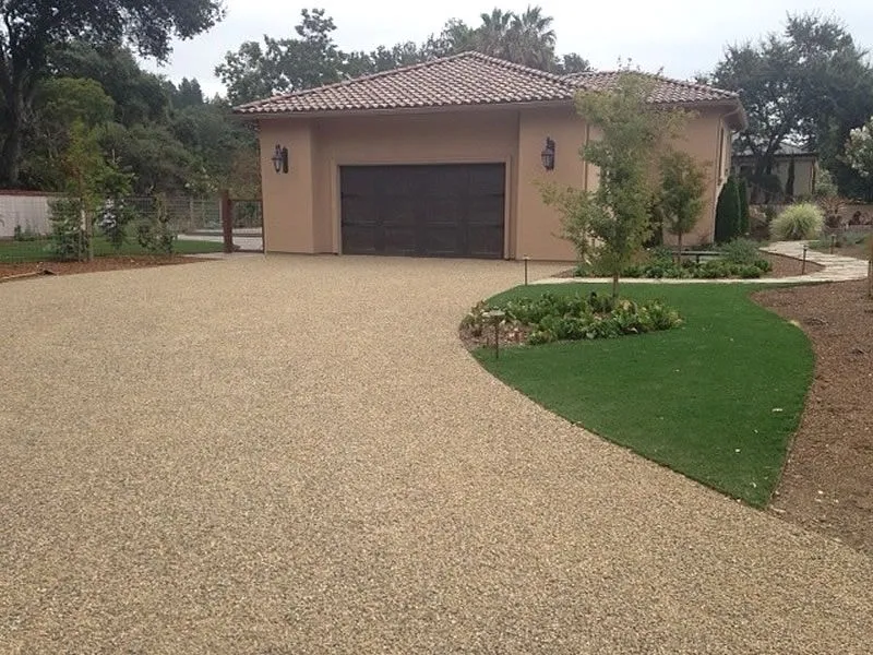 Completed chip-seal driveway leading to a residential garage